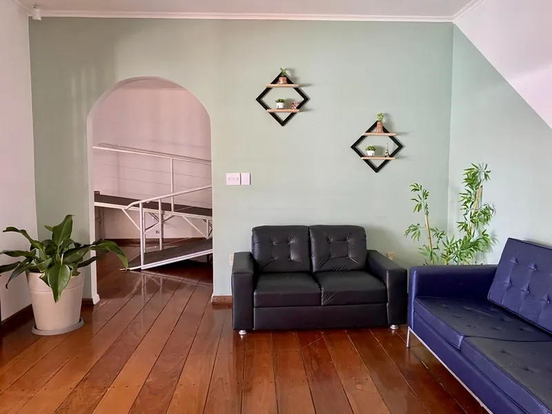 Sala interna com paredes verdes, sofás e rampa de acessibilidade ao fundo